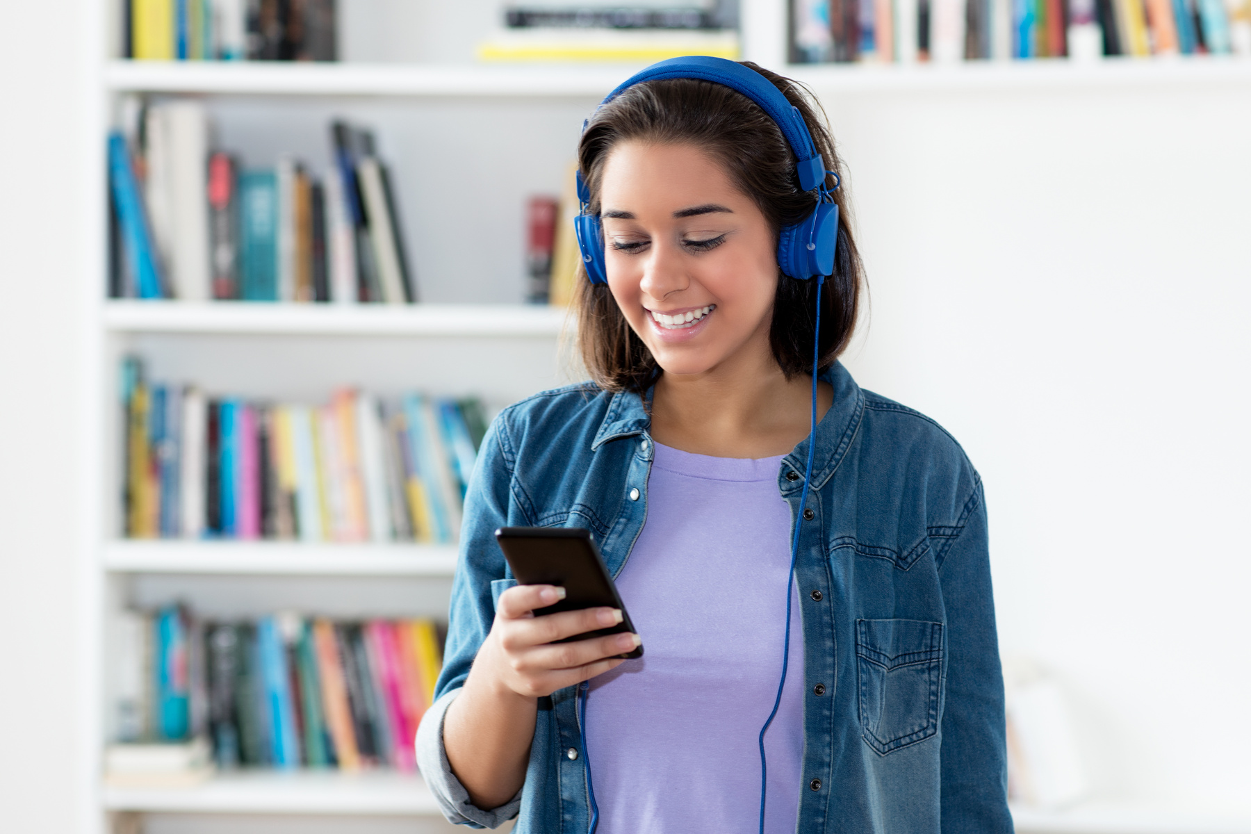 Spanish young adult woman listening to podcast